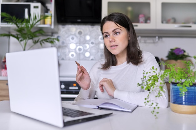 Foto comunicação online, consulta, treinamento, negócios. professora, mentora, psicóloga olhando para a webcam do laptop, conversando, aconselhando, tomando notas conceito de estilo de vida à distância de tecnologia