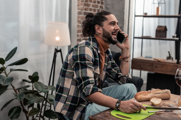 Foto comunicación agradable. hombre positivo feliz sonriendo mientras habla con su amigo