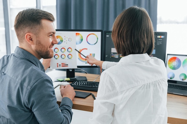 Foto comunicación positiva dos diseñadores trabajando juntos en la oficina