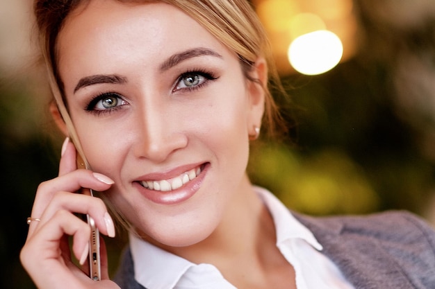 Comunicación tecnológica y concepto de personas mujer joven feliz llamando a un teléfono inteligente en la oficina