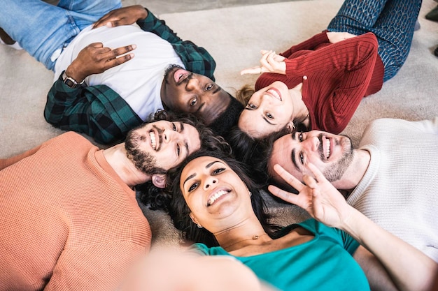 Comunidade multirracial de jovens deitados na sala de estar do campus Amigos multiculturais felizes tirando fotos de selfie e sorrindo juntos para a câmera Conceito de inclusão e diversidade