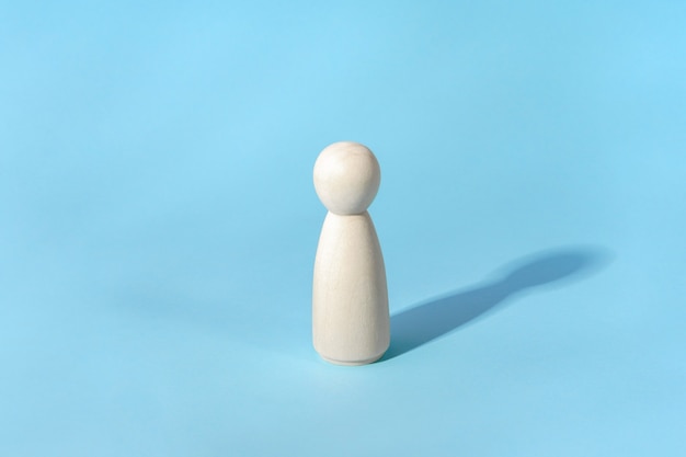 Conceito abstrato de figura de madeira minimalista de pessoa solitária com sombra azul