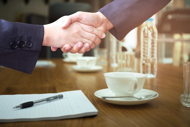 Conceito acordo de negócios mãos tremendo na sala de conferências com café