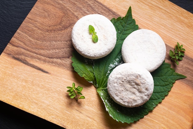 Foto conceito alimentar queijo de cabra orgânico francês picodon do sul da frança em placa de madeira com espaço de cópia