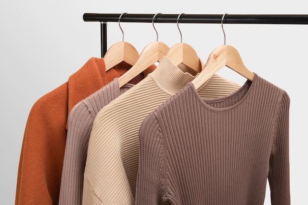 Foto conceito básico de guarda-roupa feminino de outono em trilhos no showroom conceito de tendências de moda de outono