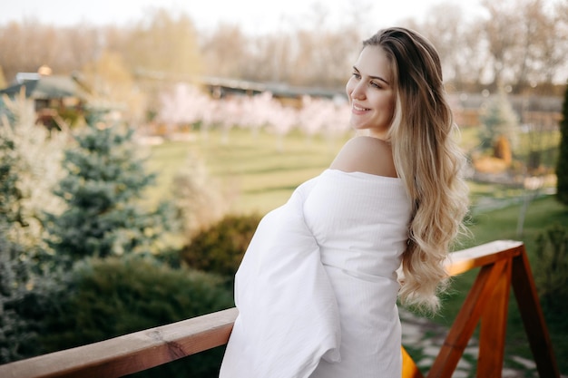 Conceito bom dia mulher loira na varanda coberta com edredão branco retrato de mulher matinal