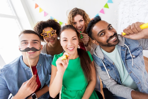 Foto conceito corporativo, de celebração e de feriados - amigos felizes ou equipe com acessórios de festa se divertindo no escritório