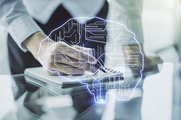 Conceito criativo de inteligência artificial com holograma do cérebro humano e escrita à mão do homem no notebook no fundo Multiexposição