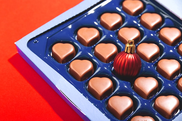 Conceito criativo de Natal com bola de Natal em caixa de chocolates em forma de coração.