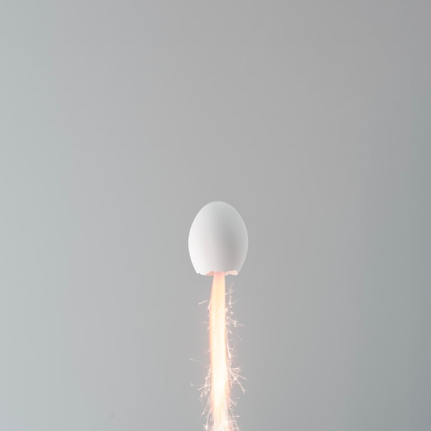 Foto conceito criativo minimalista de páscoa o ovo de páscua branco em forma de foguete voa