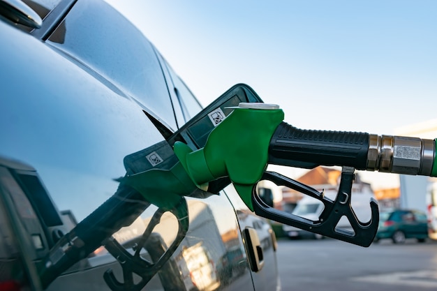 Conceito da indústria, dos óleos e dos combustíveis: reabastecendo um carro em um posto de gasolina.