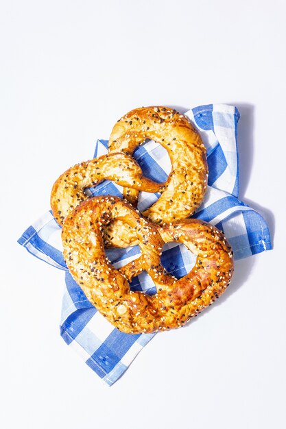 Conceito da oktoberfest - pretzels em um guardanapo tradicional, isolado no fundo branco. uma luz forte, sombra escura da moda