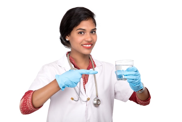 Conceito de alimentação ou estilo de vida saudável: médica sorridente segurando um copo de água doce