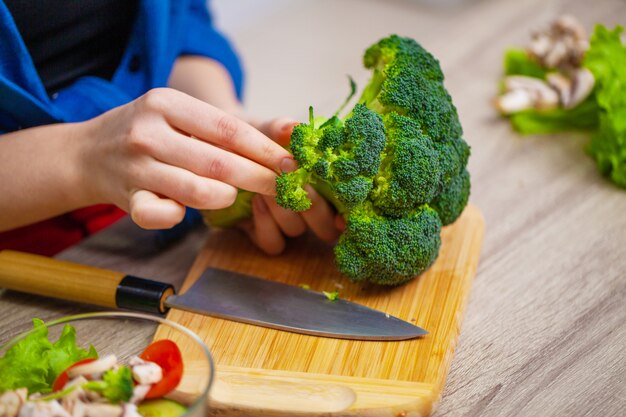 Conceito de alimentação saudável, mulher corta legumes frescos para salada