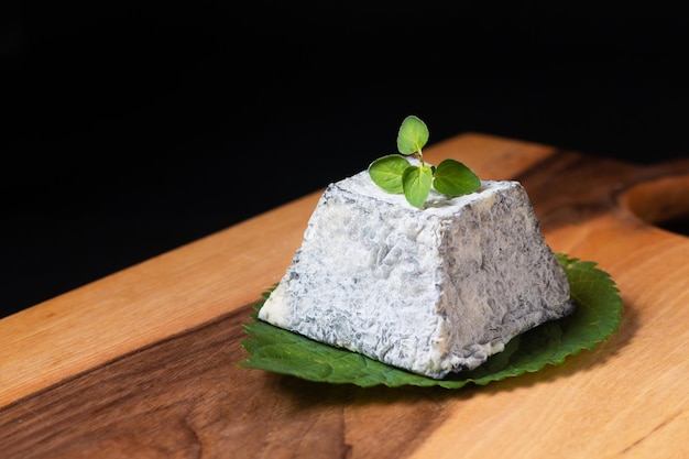 Foto conceito de alimentos orgânicos queijo valencay pdo forma de pirâmide na placa de madeira com espaço de cópia