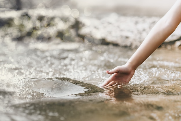 Conceito de ambiente, toque natural, mão toca a água na natureza