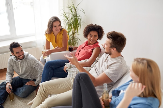 conceito de amizade, comunicação e pessoas - grupo de amigos felizes com bebidas conversando em casa