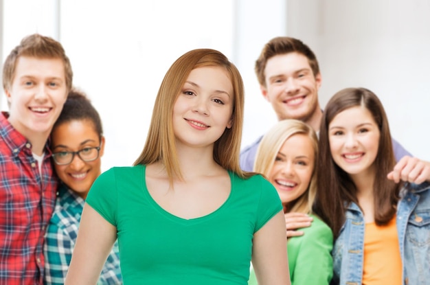 Foto conceito de amizade, juventude e pessoas - grupo de adolescentes multirraciais sorridentes sobre fundo de sala de aula