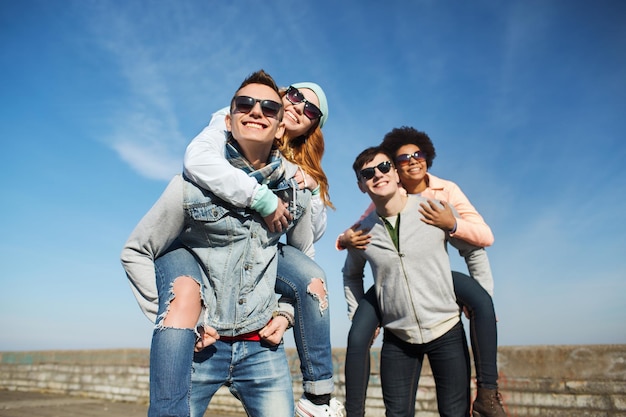 conceito de amizade, lazer e pessoas - grupo de amigos adolescentes felizes em óculos de sol se divertindo ao ar livre