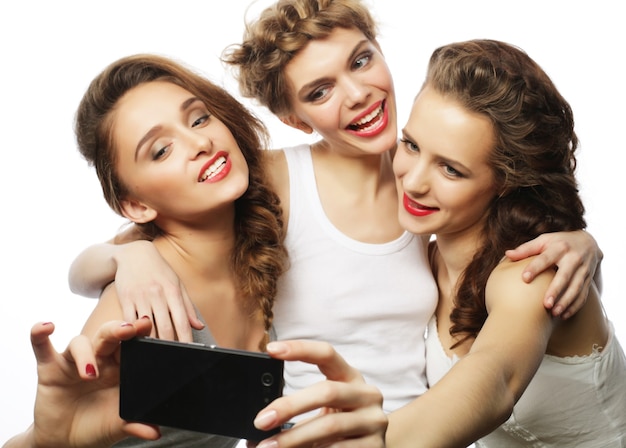 Conceito de amizade, pessoas e tecnologia - três adolescentes felizes com smartphone tirando selfie