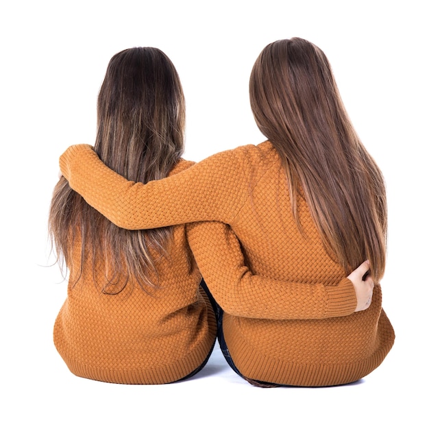Conceito de amizade - vista traseira de duas meninas sentadas isoladas em fundo branco