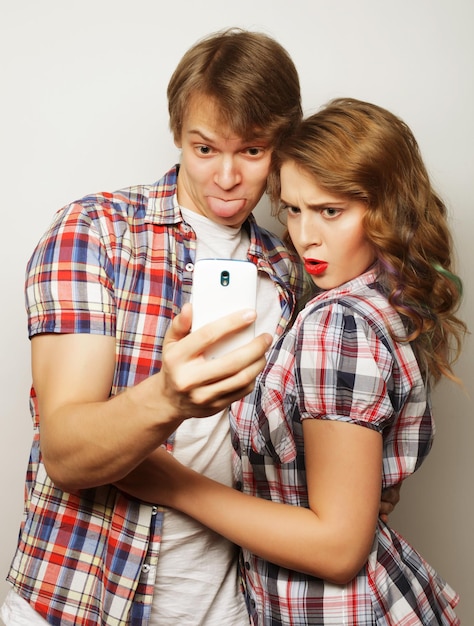 Conceito de amor e amizade de tecnologia casal sorridente com selfie de smartphone e diversão studio atirou sobre fundo branco