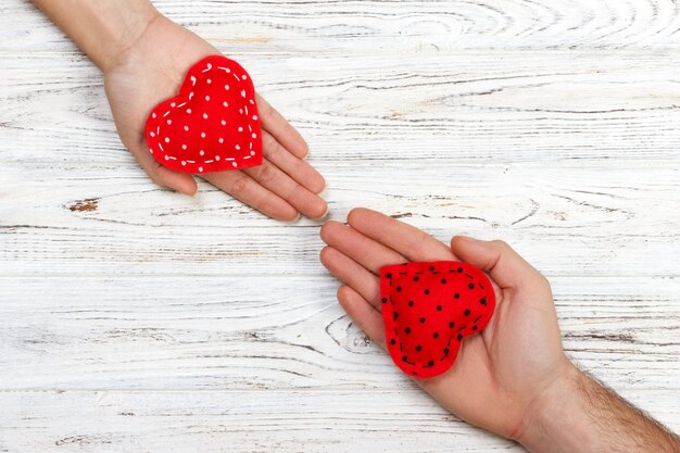 Conceito de amor: Menina segurando e dando coração vermelho para a mão do namorado isolado
