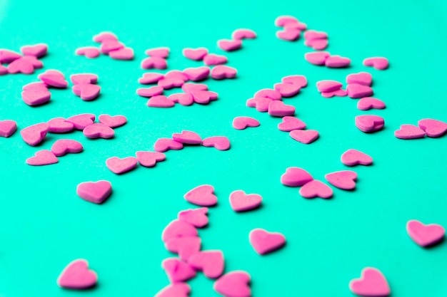 Foto conceito de amor mínimo. corações de açúcar doce em um fundo colorido