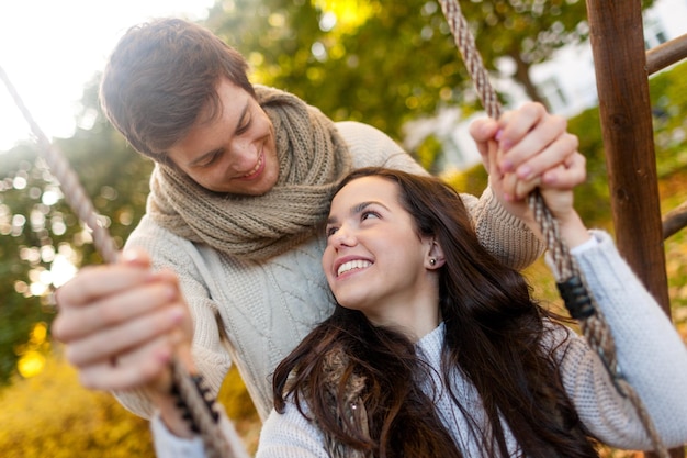 Conceito de amor, relacionamento, família e pessoas - casal sorridente abraçando no parque outono