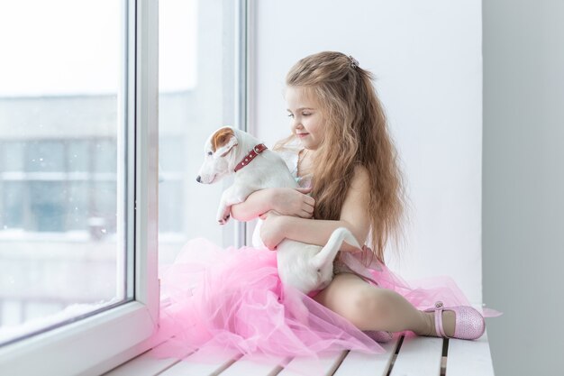 Conceito de animal de estimação e crianças - criança com cachorro Jack Russell Terrier em casa.