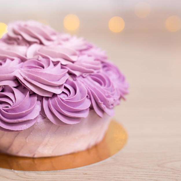 Foto conceito de aniversário - close up de um lindo bolo roxo sobre fundo de madeira