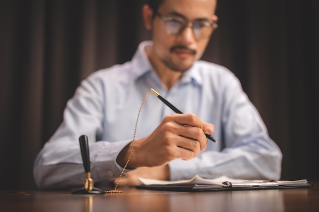 Conceito de aprovação de documento de advogado de negócios empresário profissional usando uma caneta para assinar assinatura para aceitação de acordo uma papelada de contrato ou acordo financeiro no escritório moderno