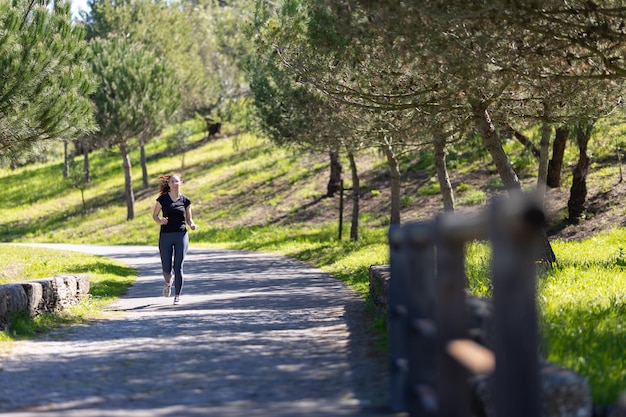 Conceito de aptidão uma mulher adulta em óculos correndo no parque