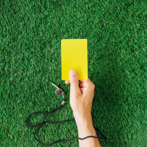 Foto conceito de árbitro com a mão segurando o cartão amarelo