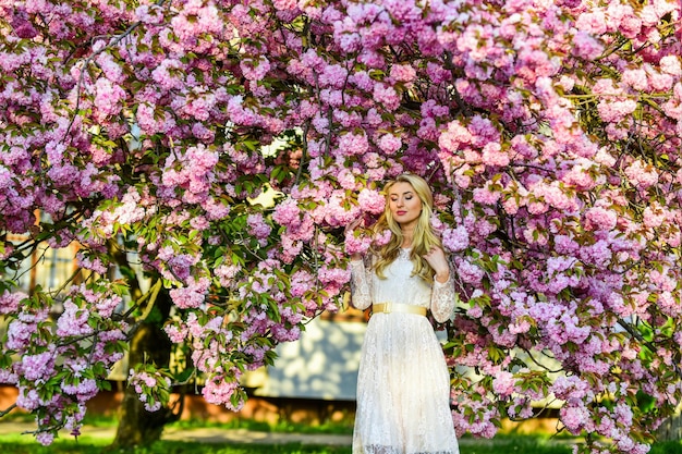 Foto conceito de aroma árvore de sakura florescendo estação de sakura fragrância suave alergia sazonal perdido em flores flor de cerejeira menina moda primavera mulher flor de sakura primavera mulher loira no jardim