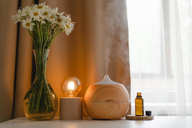 Conceito de aromaterapia Difusor de óleo de aroma na mesa contra a janela Ambientador Difusor de aroma ultrassônico para casa