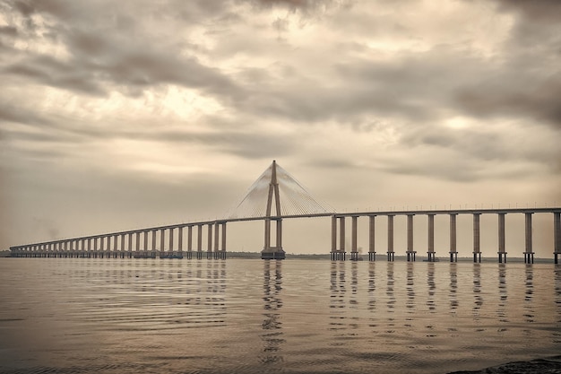 Conceito de arquitetura e design Ponte sobre o mar em manaus brasil Passagem de estrada sobre a água no céu nublado Destino de viagem e desejo de viajar