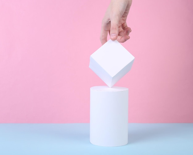 Foto conceito de arte conceitual mão feminina e formas geométricas em um fundo bluepink minimalismo