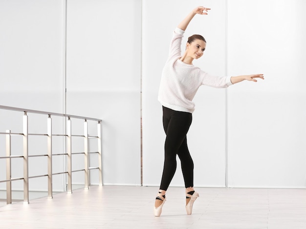 Conceito de arte de balé Jovem linda bailarina treinando no salão de dança