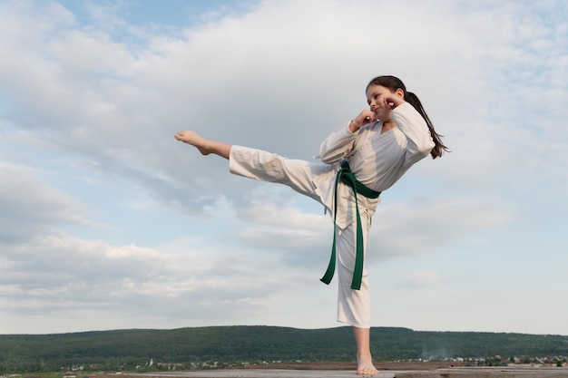 Conceito de arte marcial adolescente praticando arte marcial menina lutadora marcial no fundo do céu