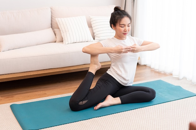 Conceito de atividade produtiva uma garota com um coque vestindo a camiseta branca fazendo o difícil movimento de pilates.