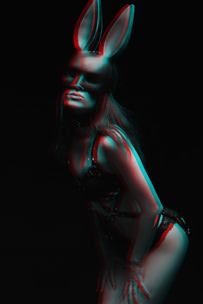Foto conceito de bdsm. garota sexy em lingerie de couro preta e uma máscara de um coelho.