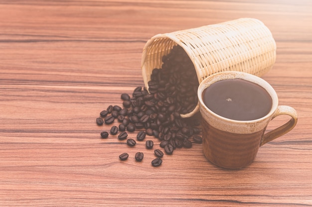 Conceito de beber café Os grãos de café e as xícaras de café estão na mesa