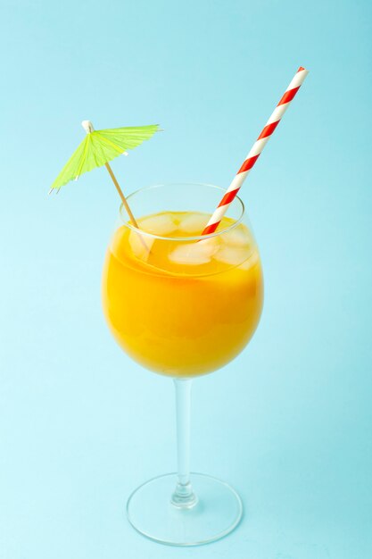 Conceito de bebidas de verão. Suco de laranja em um copo de vidro em um fundo azul colorido. Fundo mínimo de verão tropical