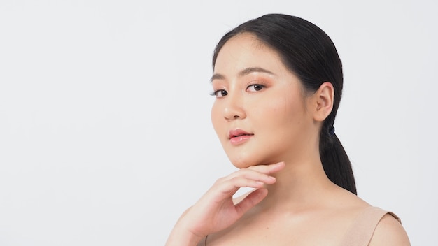 Conceito de beleza e pele. rosto de beleza jovem mulher asiática compensa cosméticos para a pele e mostrando bem-estar natural, pele facial macia, firme e sem idade.