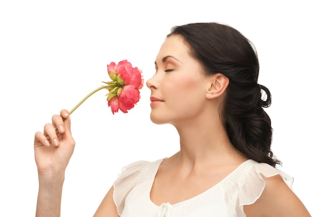 Foto conceito de beleza - foto de mulher jovem e bonita cheirando a flor