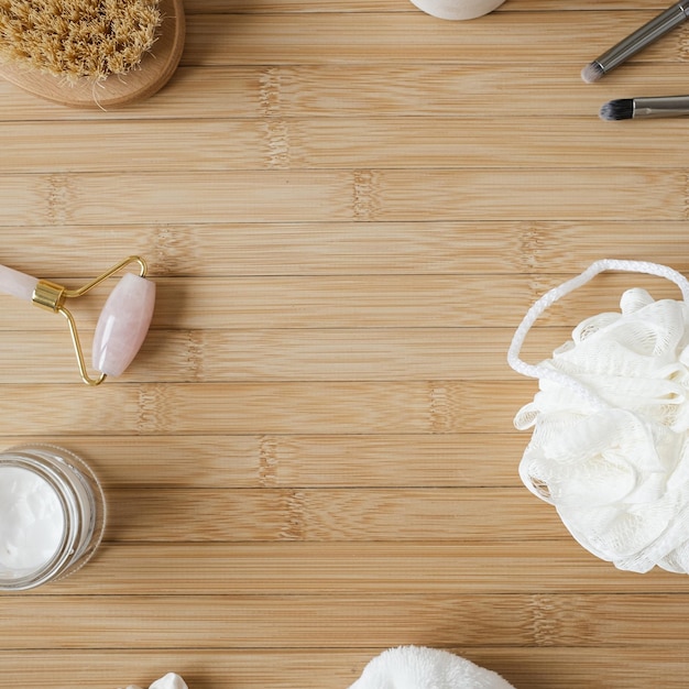 Conceito de bem-estar spa com produtos de banho em fundo de madeira com espaço de cópia Escova esponja guasha Configuração estética minimalista do chuveiro