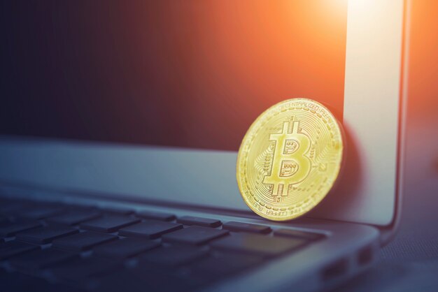 Conceito de Bitcoin. Bitcoin dourado colocar no teclado do laptop com tela vazia com luz