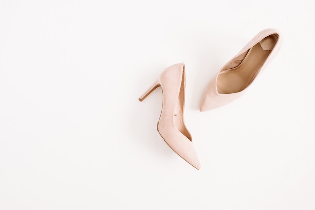 Foto conceito de blog de moda. sapatos de salto alto de mulheres rosa pálido em fundo branco. camada plana, vista superior