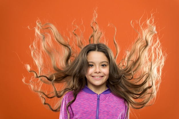 Conceito de cabelo forte e saudável. Como tratar o cabelo crespo. Penteado bonito e arrumado. Dicas fáceis para fazer penteados para crianças. Cabelo comprido de criança pequena. Beleza charmosa. Garoto ativo da menina com cabelo longo lindo.
